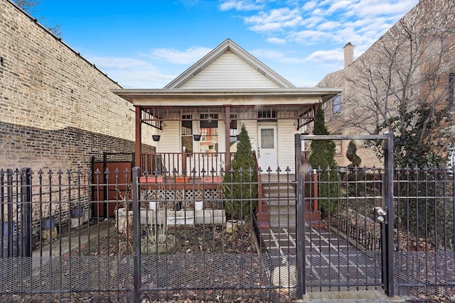 view of front facade with a fenced front yard, a gate, and a porch