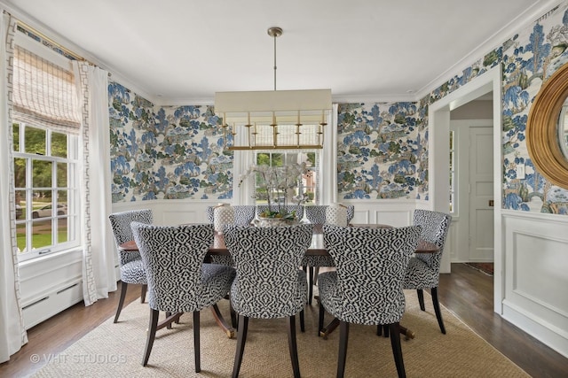 dining area featuring ornamental molding, hardwood / wood-style floors, and a baseboard heating unit