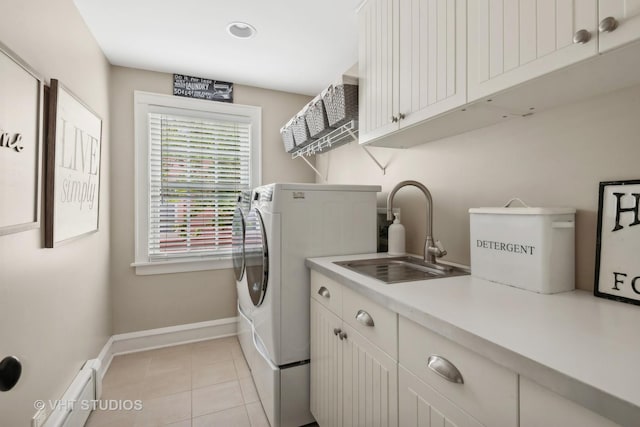 washroom with sink, cabinets, separate washer and dryer, light tile patterned floors, and a baseboard radiator