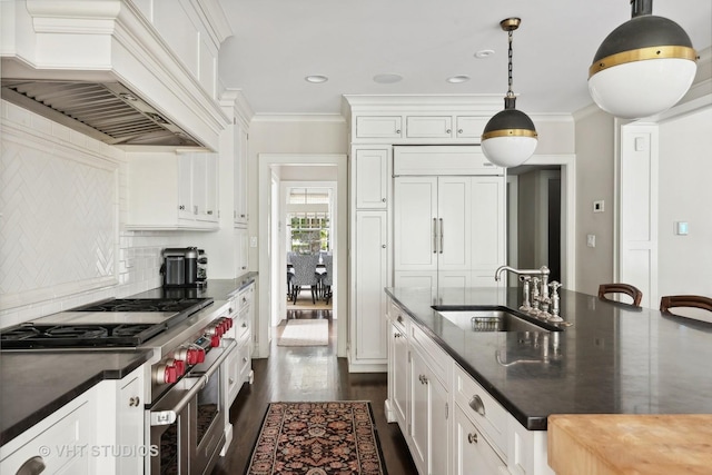 kitchen with sink, white cabinetry, hanging light fixtures, premium appliances, and custom range hood