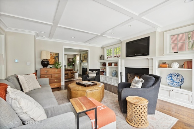 living room with coffered ceiling, hardwood / wood-style flooring, beam ceiling, and ornamental molding