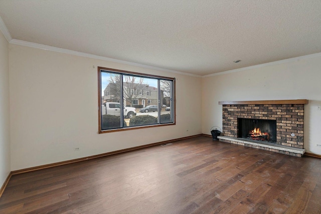 unfurnished living room with dark wood-type flooring, ornamental molding, a brick fireplace, and a textured ceiling