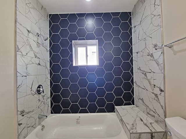 bathroom with tiled shower / bath and toilet