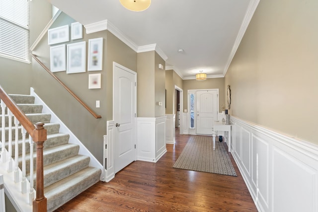 foyer entrance with ornamental molding and dark hardwood / wood-style floors