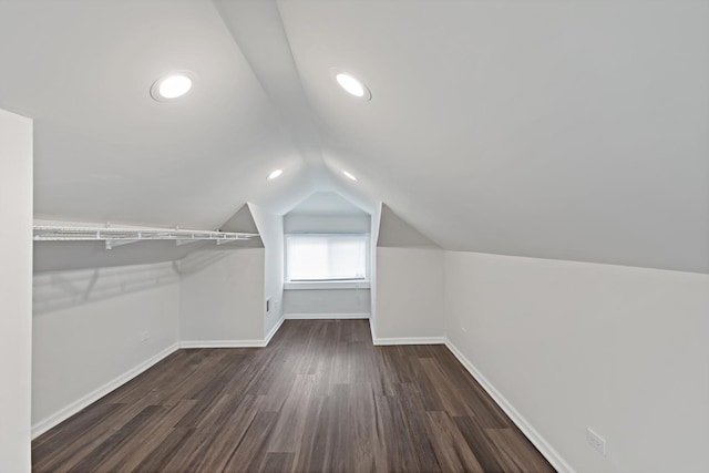 walk in closet with dark wood-type flooring and vaulted ceiling