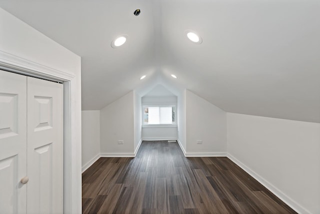 additional living space featuring lofted ceiling and dark wood-type flooring