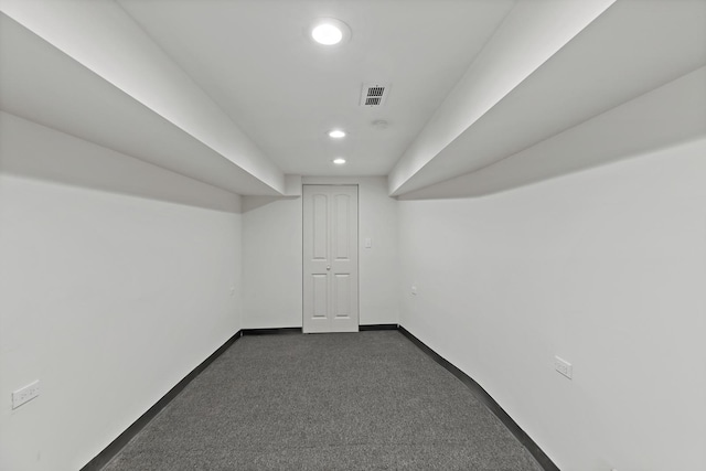 basement featuring dark colored carpet