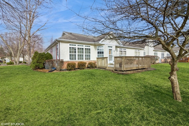 rear view of property with a wooden deck and a yard