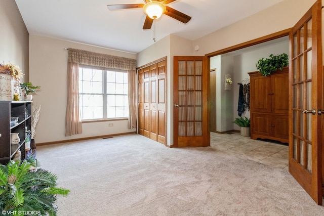 interior space with ceiling fan and light colored carpet