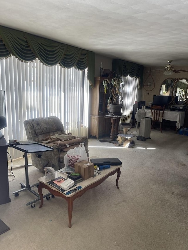 living area with carpet floors, a ceiling fan, and a wealth of natural light