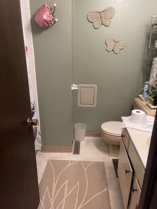 full bath featuring toilet, a shower with shower curtain, vanity, baseboards, and tile patterned floors