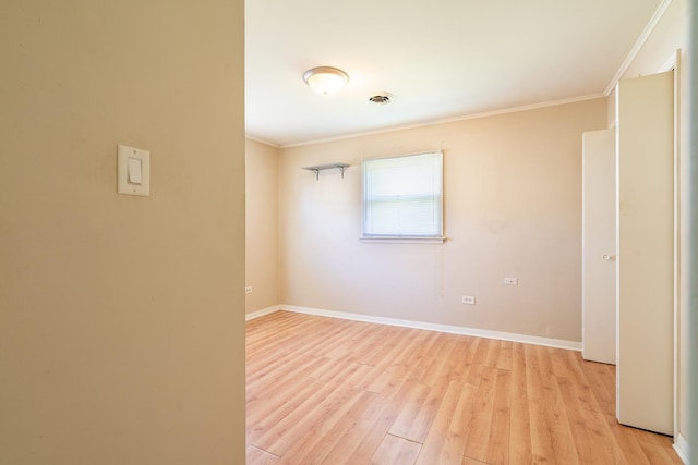 spare room with crown molding and light hardwood / wood-style flooring