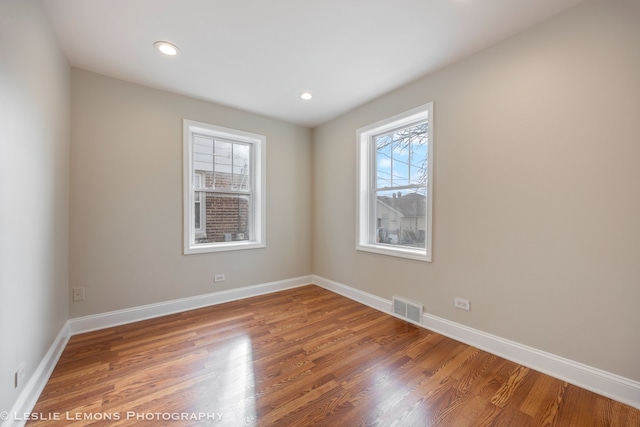 spare room with hardwood / wood-style floors and a healthy amount of sunlight