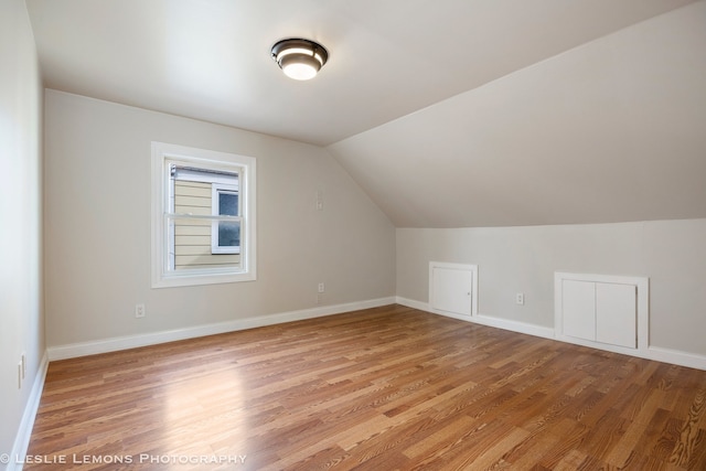 bonus room with vaulted ceiling and light wood-type flooring