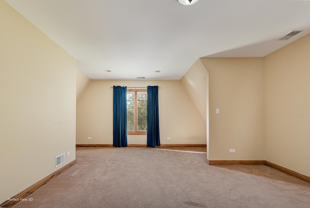 spare room with light carpet and lofted ceiling