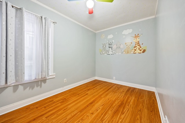 spare room with hardwood / wood-style flooring, crown molding, and ceiling fan