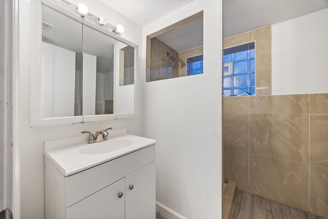 bathroom with vanity and a tile shower