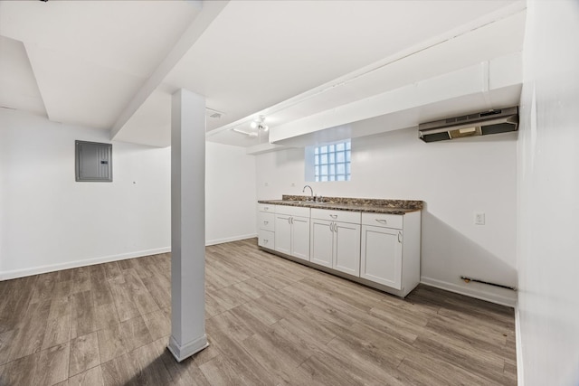 basement with sink, electric panel, and light hardwood / wood-style floors