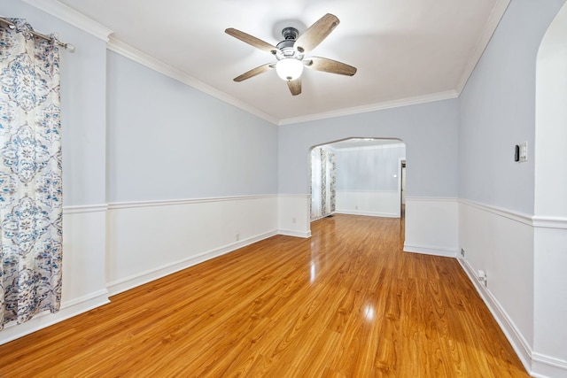 empty room with ornamental molding, ceiling fan, and light wood-type flooring