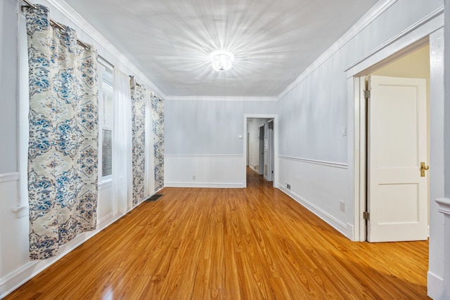 unfurnished room featuring ornamental molding and light hardwood / wood-style floors