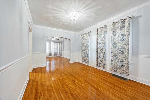 spare room featuring ornamental molding and light wood-type flooring