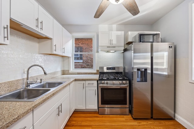 kitchen featuring sink, white cabinets, ceiling fan, stainless steel appliances, and light wood-type flooring