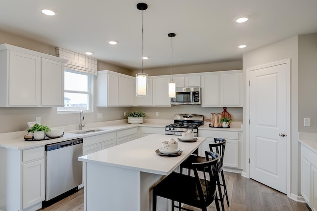 kitchen with stainless steel appliances, a kitchen island, and white cabinets