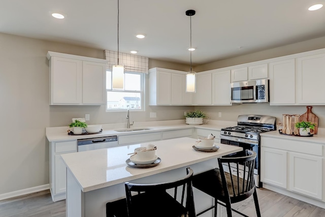 kitchen featuring a kitchen island, appliances with stainless steel finishes, sink, and white cabinets