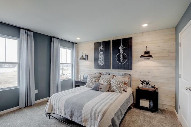 carpeted bedroom featuring wood walls