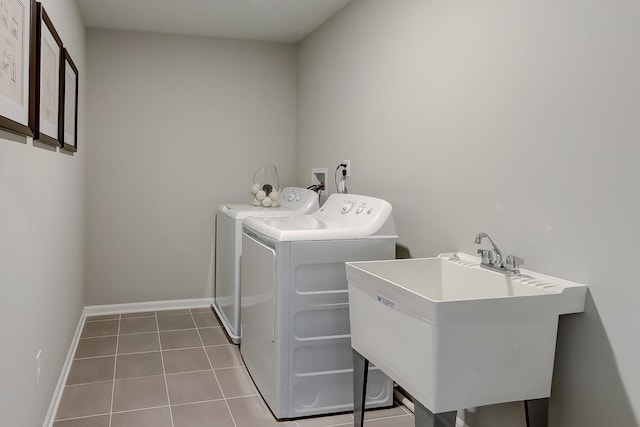 laundry area featuring sink, washer and dryer, and light tile patterned floors