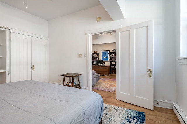 bedroom featuring light wood-style floors and a baseboard radiator