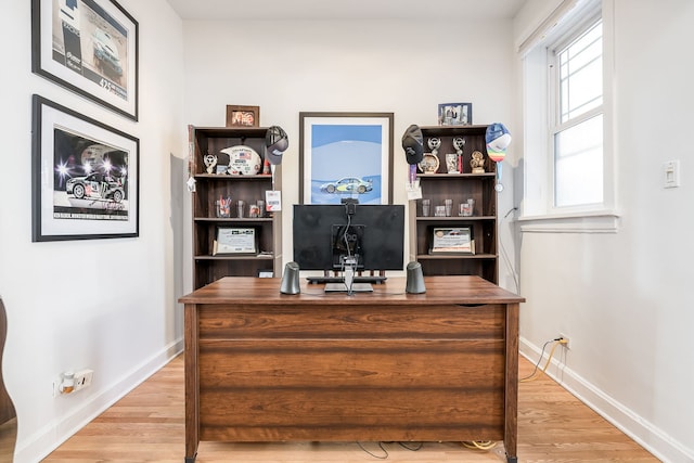 home office with light wood-type flooring and baseboards