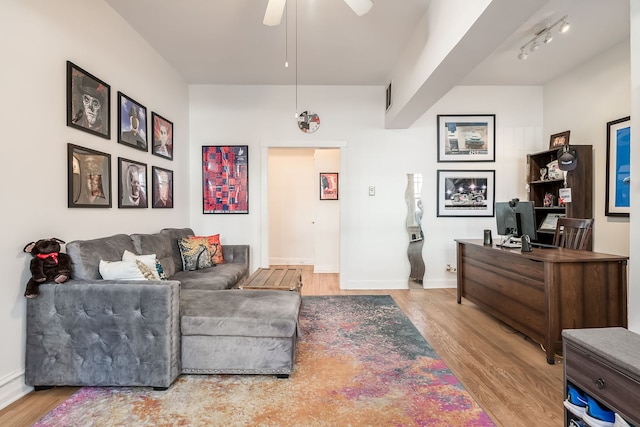 living area featuring light wood finished floors, visible vents, baseboards, a ceiling fan, and rail lighting