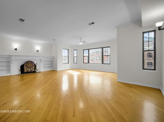 unfurnished living room with visible vents, a fireplace with flush hearth, baseboards, and light wood-style floors