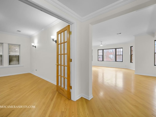 spare room featuring baseboards, wood finished floors, and ornamental molding