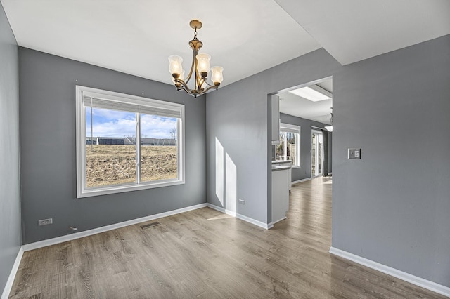 unfurnished dining area with hardwood / wood-style flooring and an inviting chandelier