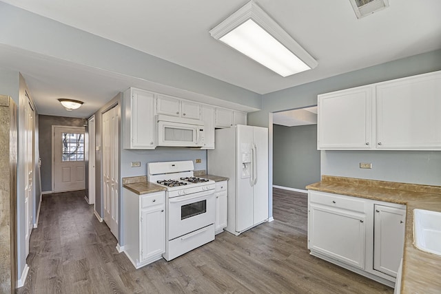 kitchen with white cabinets, white appliances, and light hardwood / wood-style floors