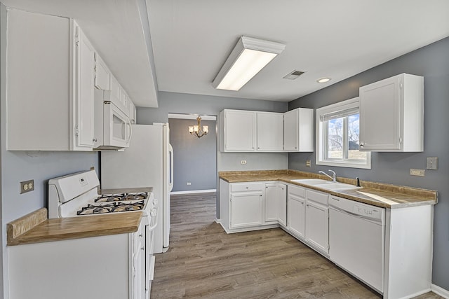 kitchen featuring white cabinetry, sink, white appliances, and light wood-type flooring