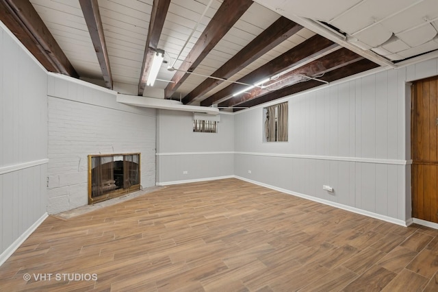 finished basement featuring a fireplace and wood finished floors