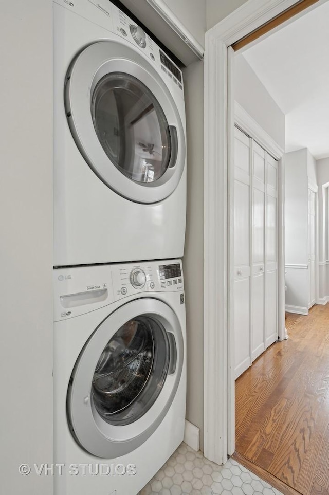 laundry area with laundry area, stacked washer / drying machine, and baseboards