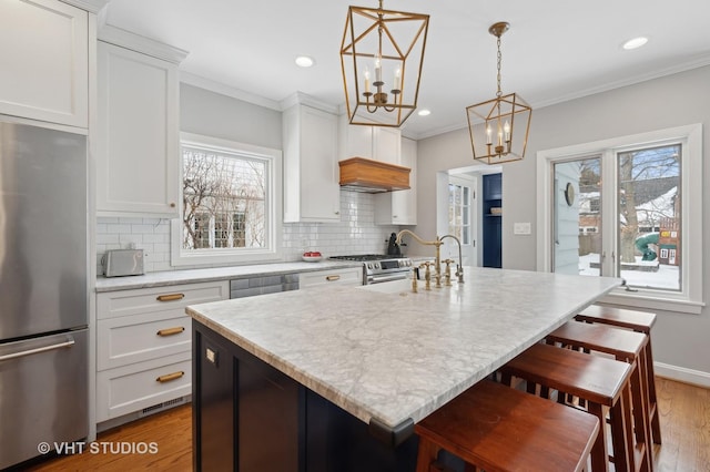 kitchen with decorative backsplash, white cabinetry, appliances with stainless steel finishes, and ornamental molding