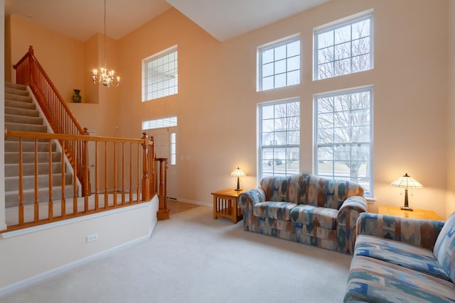 living room with an inviting chandelier, plenty of natural light, carpet floors, and a high ceiling