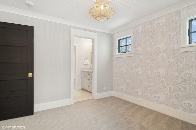 unfurnished bedroom featuring ensuite bathroom and light colored carpet