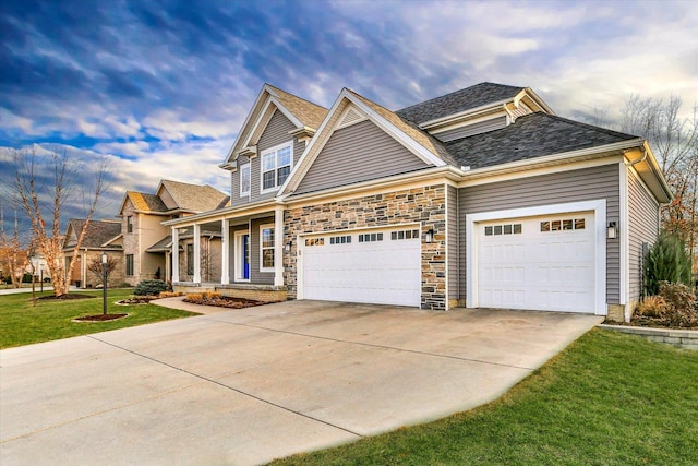 craftsman house with covered porch, a front yard, and a garage