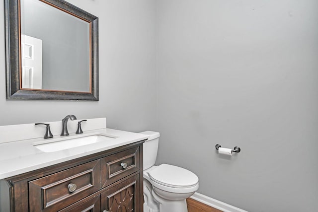 bathroom with vanity, wood-type flooring, and toilet