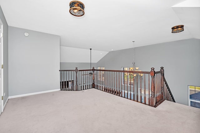 carpeted spare room featuring vaulted ceiling