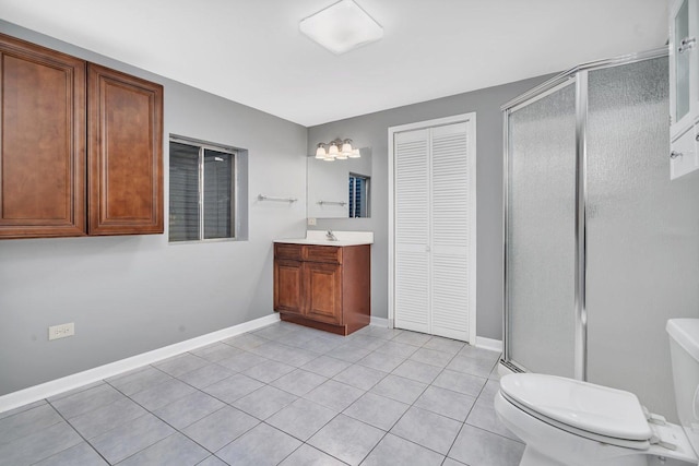 bathroom with vanity, a shower with shower door, tile patterned floors, and toilet