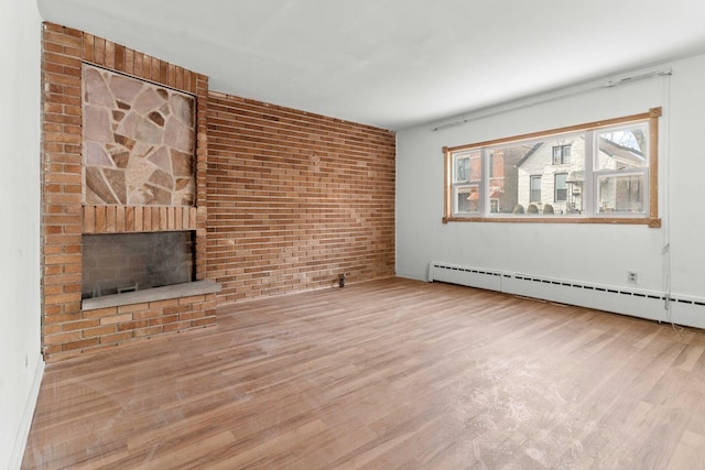 unfurnished living room featuring brick wall, a fireplace, hardwood / wood-style floors, and a baseboard heating unit