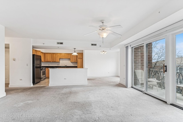 unfurnished living room featuring light carpet, visible vents, ceiling fan, and a sink