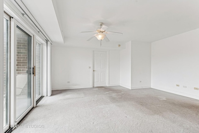 carpeted empty room featuring baseboards and ceiling fan